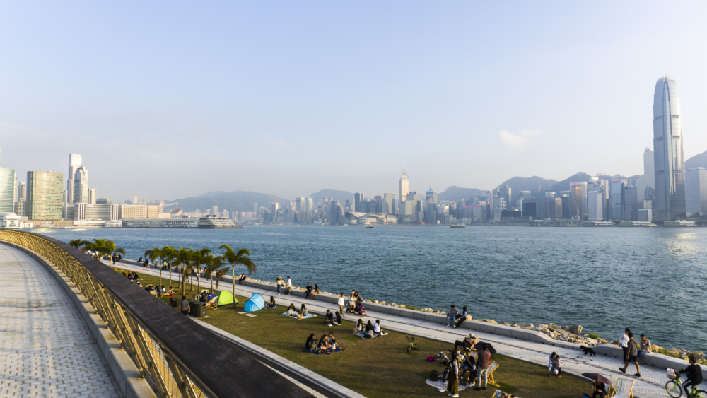 西九藝術公園擁有超大草坪與無遮擋的海濱長廊，能同時把維港與對岸港島的摩天大樓剪影拍進鏡頭。