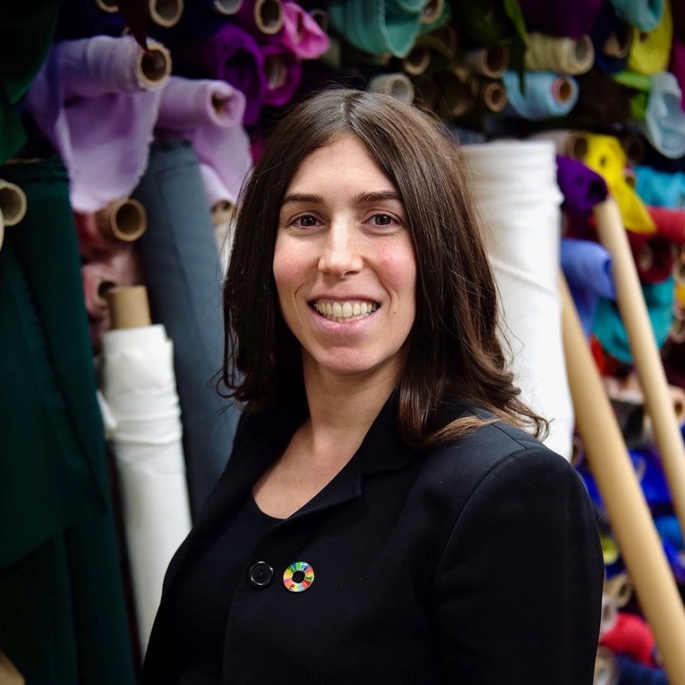 她看著家族企業與同業長年累積的閒置布料，深感這不僅是環境的災難，更是極大的經濟浪費