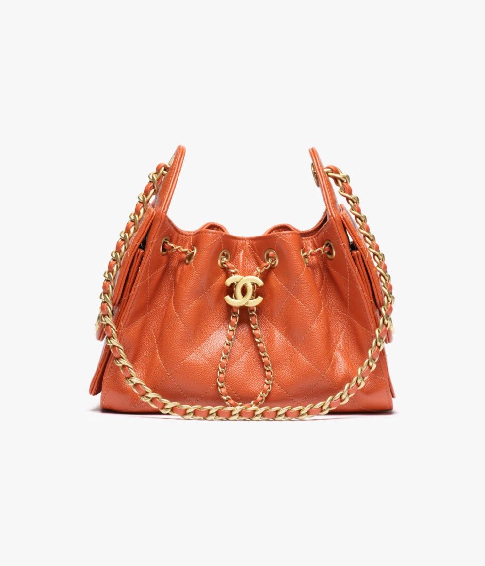飽和的深橘色，卻因為金屬鍊條與皮革的拼接，散發出一種活潑的叛逆感
