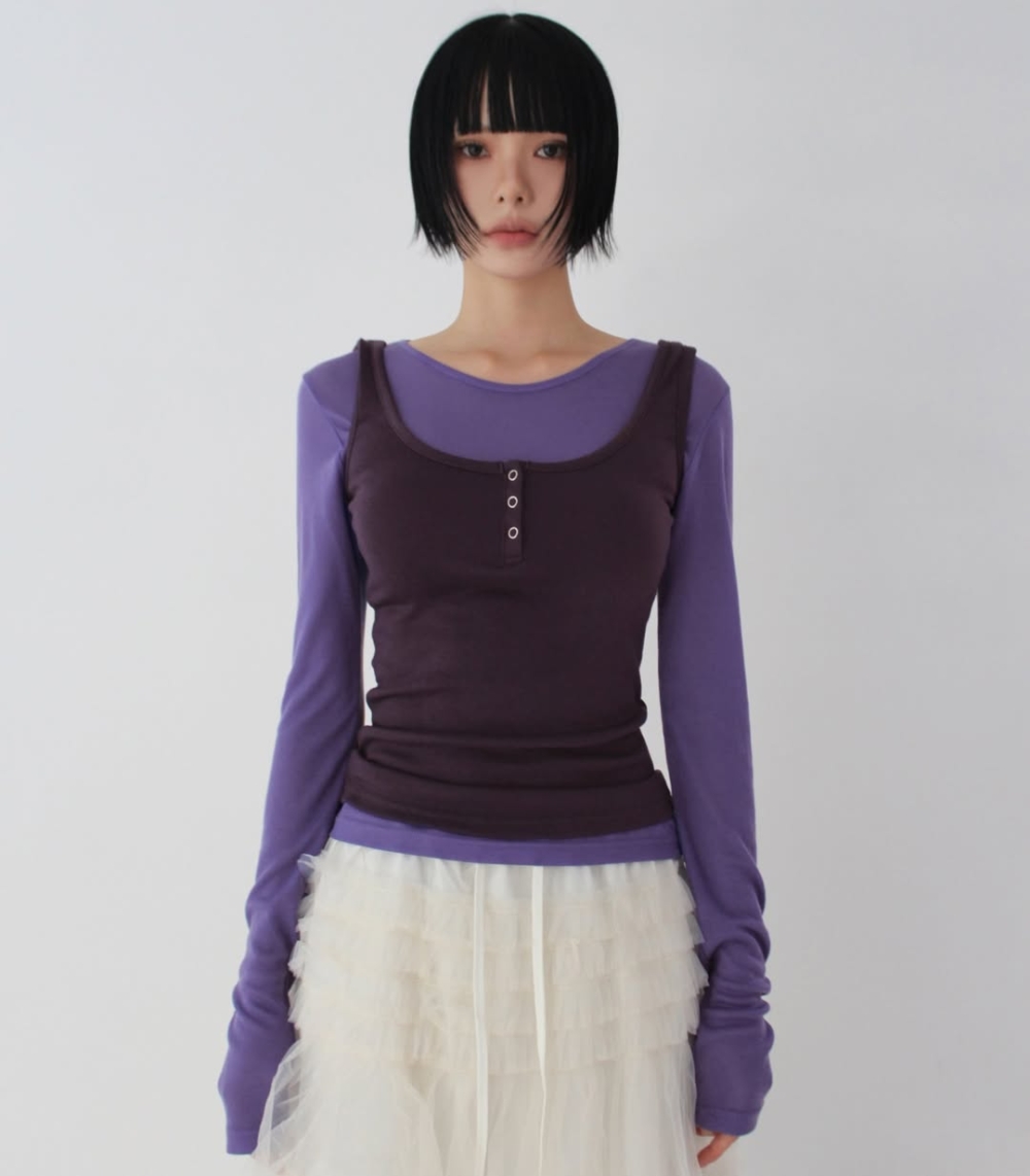 將短版背心套在上衣外，利用撞色視覺來提高腰線