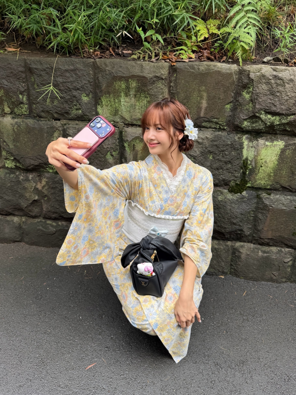 Lisa這次選擇黃色為底、點綴粉色與淡藍色花卉的浴衣，搭配白色Kitty腰帶與花朵髮飾，整體散發柔和的日系氛圍